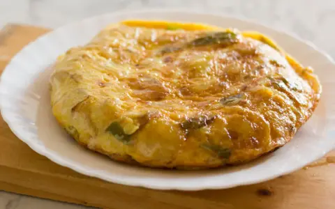 Złocista tortilla ziemniaczana z papryką na talerzu. Idealne śniadanie bez chleba, sycące i pyszne.