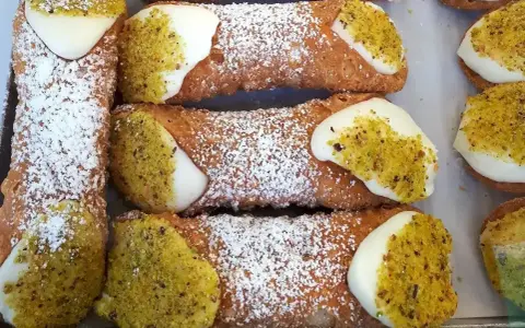 Chrupiące rurki wypełnione kremem i posypane pistacjami. Te pyszne **cannoli** wyglądają jak dzieła sztuki cukierniczej.