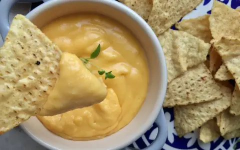 Chrupiące nachos zanurzane w kremowym sosie z serka topionego. Idealna przekąska na imprezę.