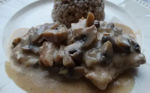 Pyszny schab duszony z pieczarkami w kremowym sosie, podany z kaszą gryczaną.