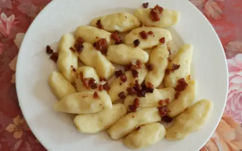 Kopytka z boczkiem, jak u babci! Pyszne ciasto na kopytka przepis babci, podane na talerzu.
