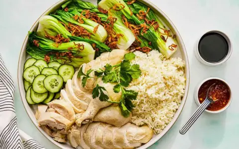 Pyszny kurczak hong kong z ryżem, pak choi, ogórkiem i sosami.