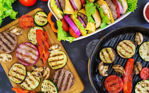 Pyszne przekąski na grilla: burgery, grillowane warzywa (cukinia, bakłażan, papryka, cebula, pomidory) i pieczarki. Idealne na letnie spotkania.