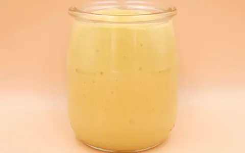 Gęsty, kremowy mango lassi w szklanym słoiku, gotowy do orzeźwiającego łyku.