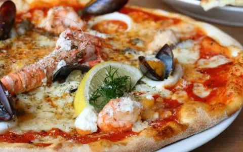 Wykwintna pizza z krewetkami, małżami i cytryną – być może najdroższa pizza na świecie, kusząca bogactwem owoców morza.