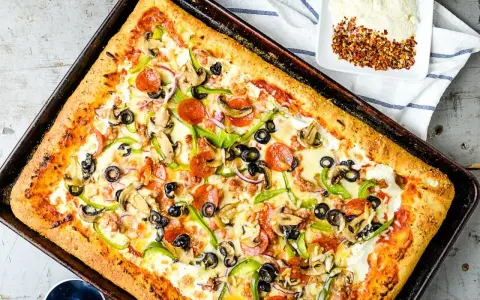 Pyszna pizza domowa na blachę z pieczarkami, papryką, oliwkami i pepperoni. Idealny przepis na szybki obiad.