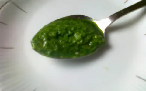 Łyżeczka pełna aromatycznego pesto z pietruszki, gotowa do podania.