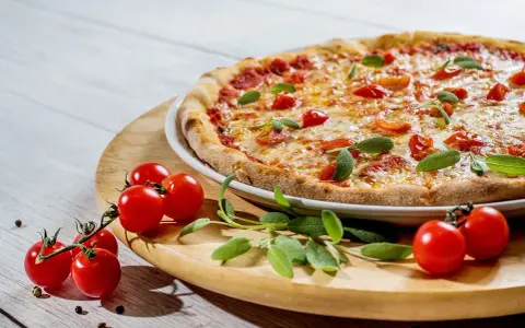 Pyszna pizza z pomidorkami i szałwią. Idealne jakie zioła do pizzy, by nadać jej śródziemnomorski smak.