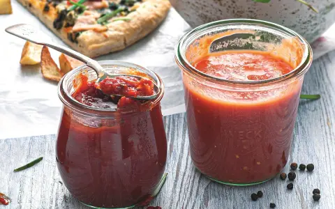 Dwa słoiczki Weck z domowymi dipami pomidorowymi, obok kawałek pizzy i miska makaronu. Idealne do pizzy i nie tylko!