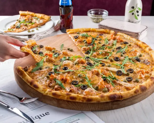 Pyszna pizza z krewetkami, oliwkami i kaparami, serwowana w klimatycznej **pizzerii Stare Miasto**. Idealna na wspólny posiłek.