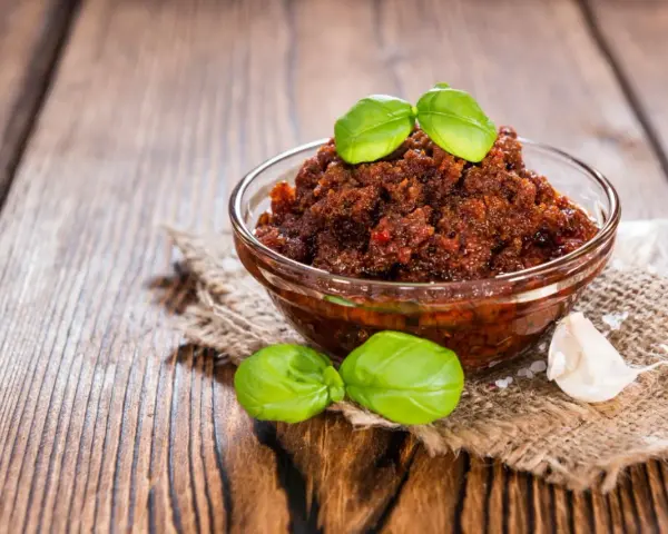Miseczka pełna aromatycznego, czerwonego pesto z bazylią i czosnkiem, gotowa do podania.