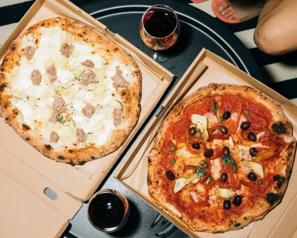 Dwie pyszne pizze: jedna biała z kiełbasą i ziemniakami, druga czerwona z oliwkami i karczochami. Takie są pizze na wieczór!