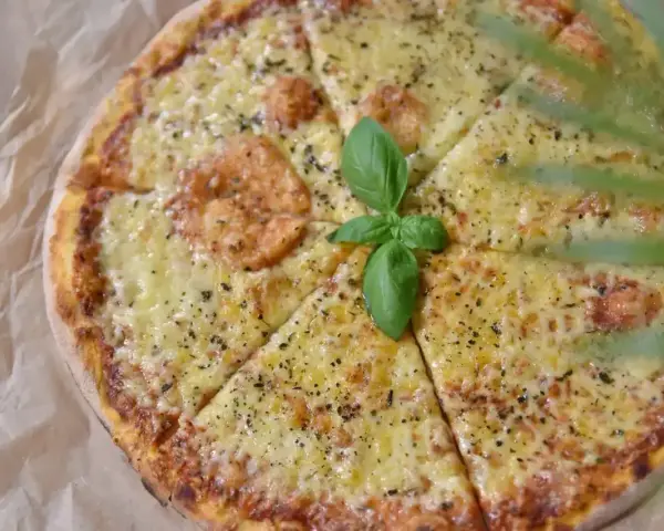 Pyszna pizza z roztopionym serem, idealna na wieczór. Zastanawiasz się, jaki ser do pizzy wybrać? Ten wygląda obłędnie!