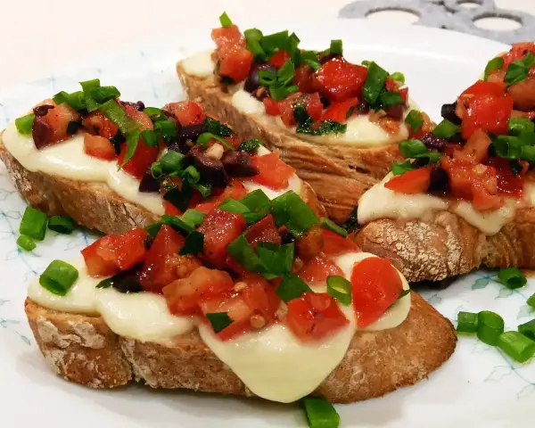Bruschetta z pomidorami i mozzarellą: chrupiące pieczywo, roztopiony ser i świeże dodatki. Idealny przepis na szybką przekąskę.
