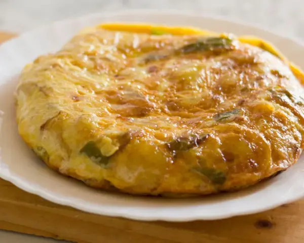 Złocista tortilla ziemniaczana z papryką na talerzu. Idealne śniadanie bez chleba, sycące i pyszne.