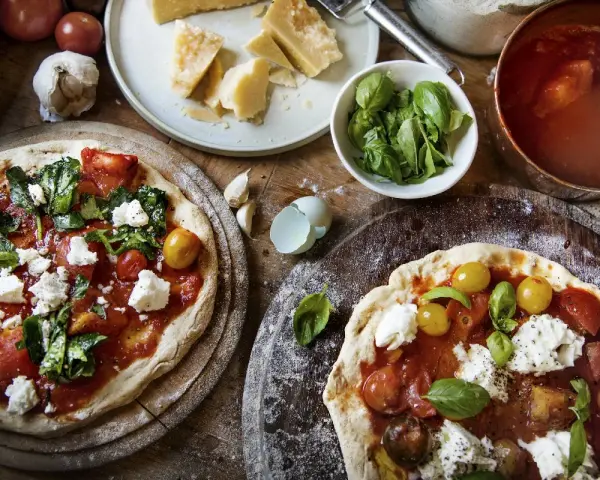 Dwie pizze margherita z pomidorami, mozzarellą i bazylią. Zastanawiasz się, ile kalorii ma pizza margherita?
