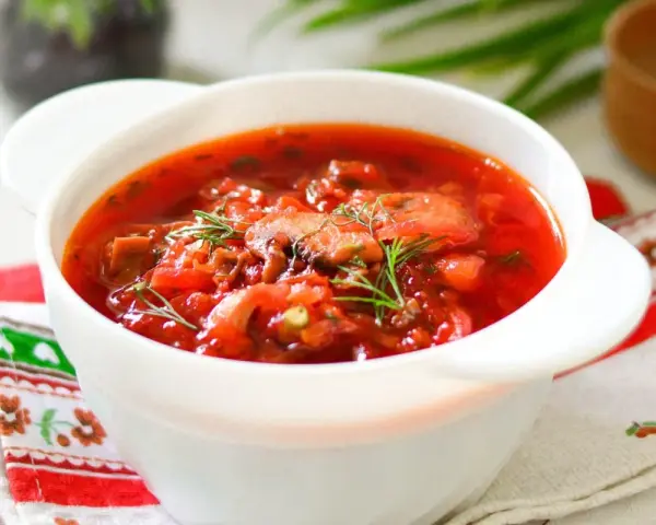 Aromaticzny barszcz ukraiński tradycyjny w białej miseczce, ozdobiony koperkiem. Idealny przepis na rozgrzewający obiad.