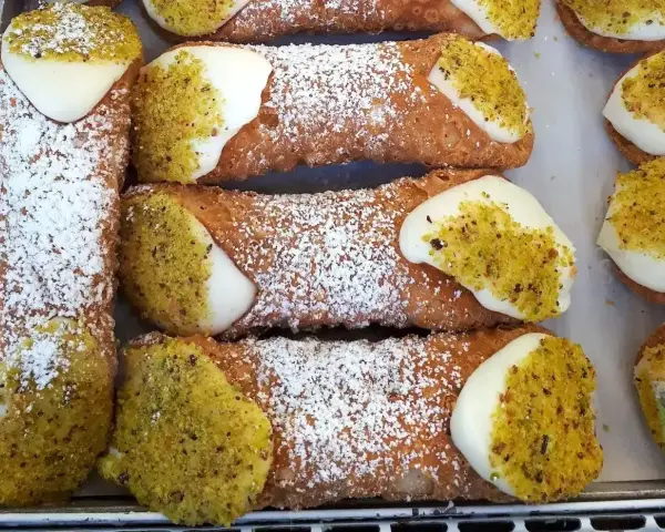 Chrupiące rurki wypełnione kremem i posypane pistacjami. Te pyszne **cannoli** wyglądają jak dzieła sztuki cukierniczej.