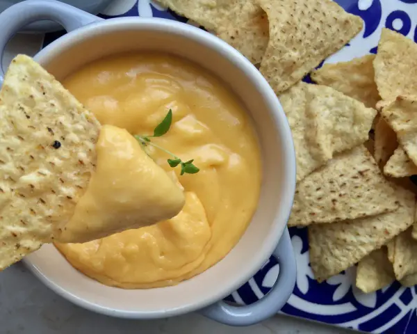 Chrupiące nachos zanurzane w kremowym sosie z serka topionego. Idealna przekąska na imprezę.