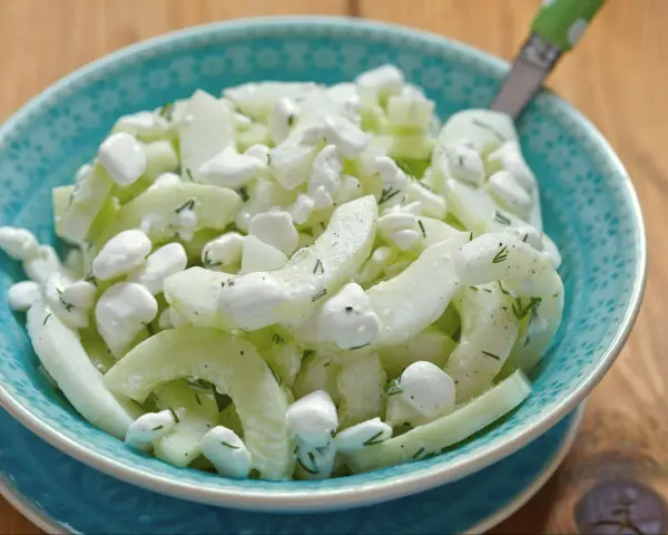 Serek wiejski z ogórkiem i koperkiem, podany w turkusowej miseczce. Lekka i orzeźwiająca przekąska.