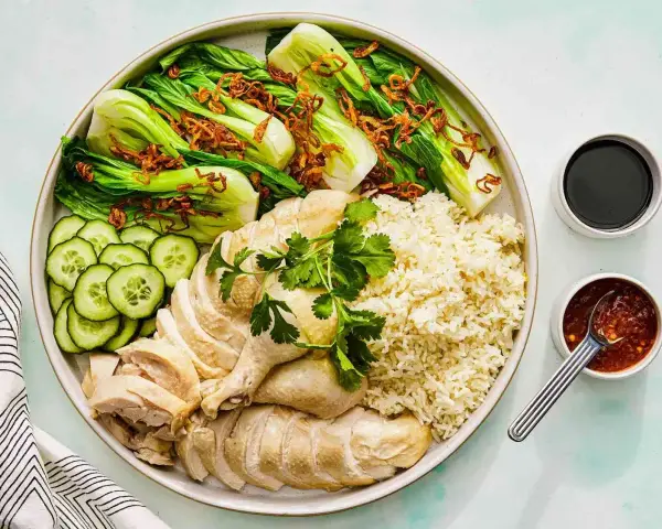 Pyszny kurczak hong kong z ryżem, pak choi, ogórkiem i sosami.