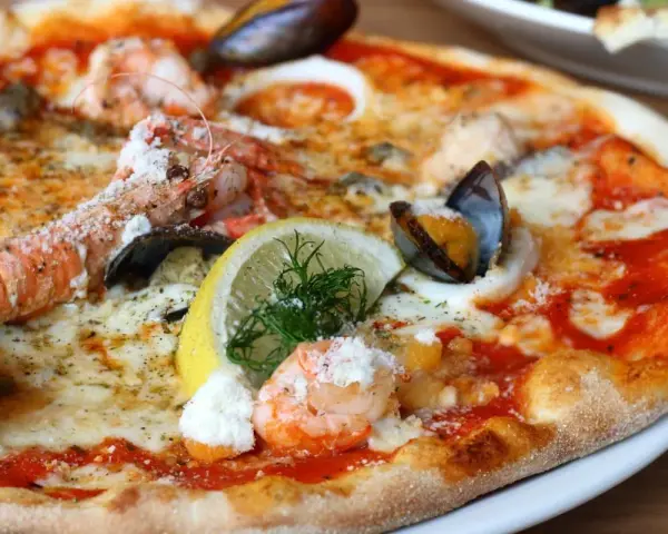 Wykwintna pizza z krewetkami, małżami i cytryną – być może najdroższa pizza na świecie, kusząca bogactwem owoców morza.