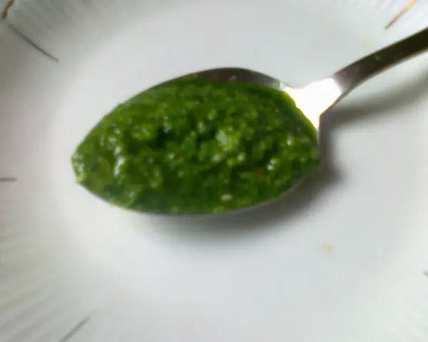 Łyżeczka pełna aromatycznego pesto z pietruszki, gotowa do podania.