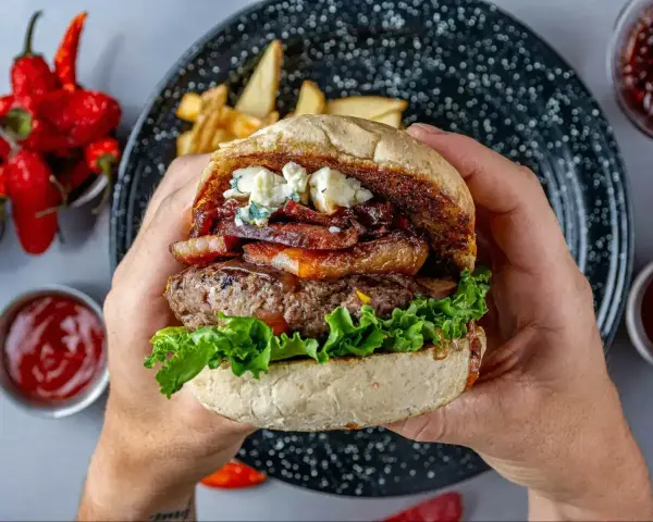 Prawdziwe burgery przepis: soczysta wołowina, chrupiący bekon, ser pleśniowy i świeża sałata w domowej bułce. Idealne na obiad!