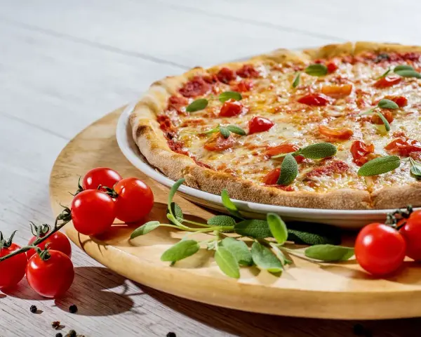 Pyszna pizza z pomidorkami i szałwią. Idealne jakie zioła do pizzy, by nadać jej śródziemnomorski smak.