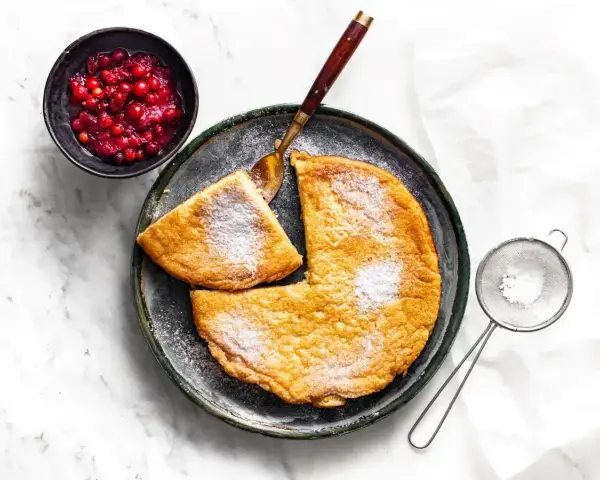 Puszysty omlet z airfryer, posypany cukrem pudrem, podany z żurawiną. Idealny na śniadanie.