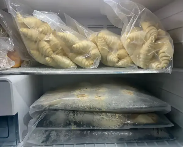 Surowe ciasto drożdżowe w woreczkach w zamrażarce.