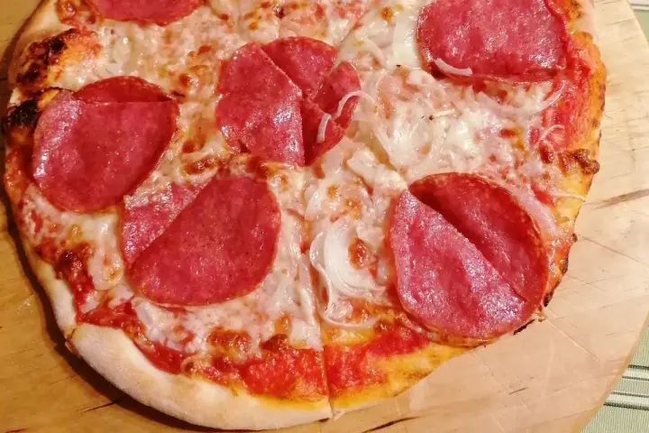 Pyszna pizza salami z serem i cebulą, idealna na szybki obiad.
