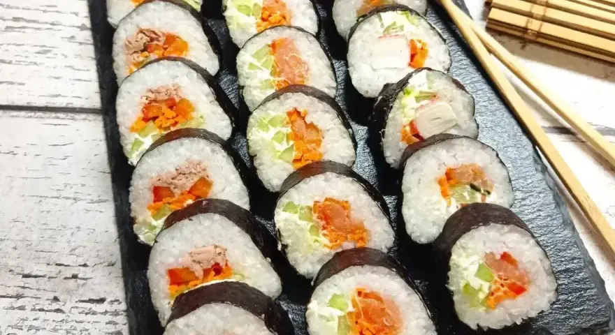 Gotowe rolki sushi z łososiem, tuńczykiem i warzywami. Prosty sposób, jak zrobić sushi w domu.