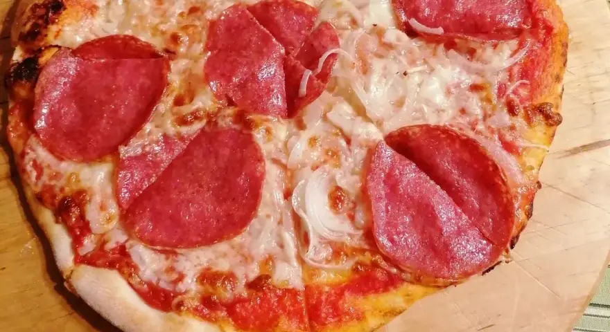 Pyszna pizza salami z serem i cebulą, idealna na szybki obiad.