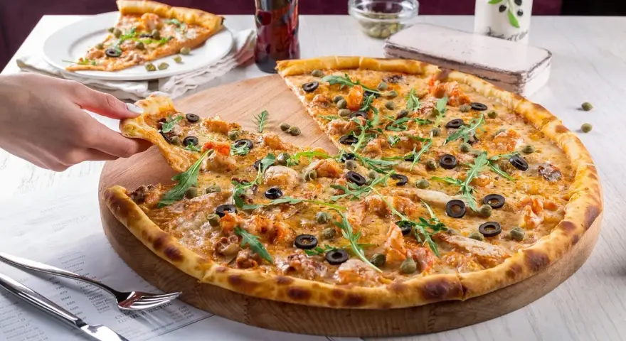 Pyszna pizza z krewetkami, oliwkami i kaparami, serwowana w klimatycznej **pizzerii Stare Miasto**. Idealna na wspólny posiłek.