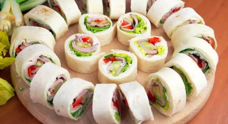 Szybkie przekąski z tortilli na zimno: roladki z szynką, serem, warzywami i sałatą. Idealne na imprezę lub lunch.