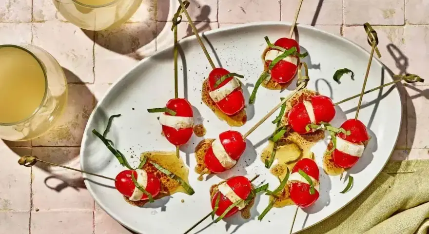 Proste przepisy na przekąski w 15 minut: szaszłyki caprese na chrupkim pieczywie z bazylią i sosem.