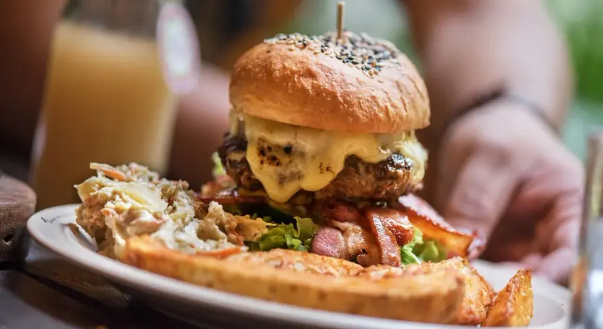 Pyszny burger drwala z rozpływającym się serem, chrupiącym boczkiem i surówką. Idealny na głód!