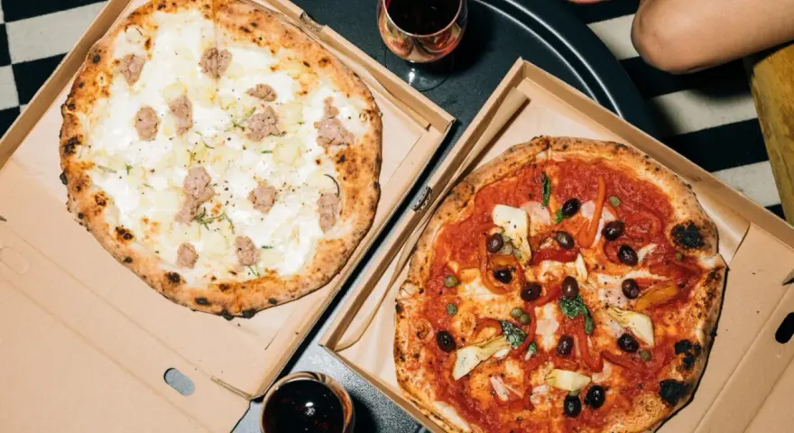 Dwie pyszne pizze: jedna biała z kiełbasą i ziemniakami, druga czerwona z oliwkami i karczochami. Takie są pizze na wieczór!