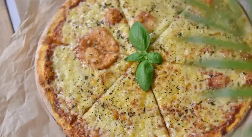 Pyszna pizza z roztopionym serem, idealna na wieczór. Zastanawiasz się, jaki ser do pizzy wybrać? Ten wygląda obłędnie!