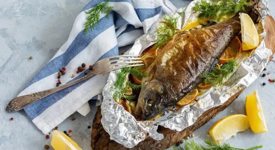 Pstrąg z grilla, pieczony w folii z cytryną i koperkiem, prezentuje się apetycznie.