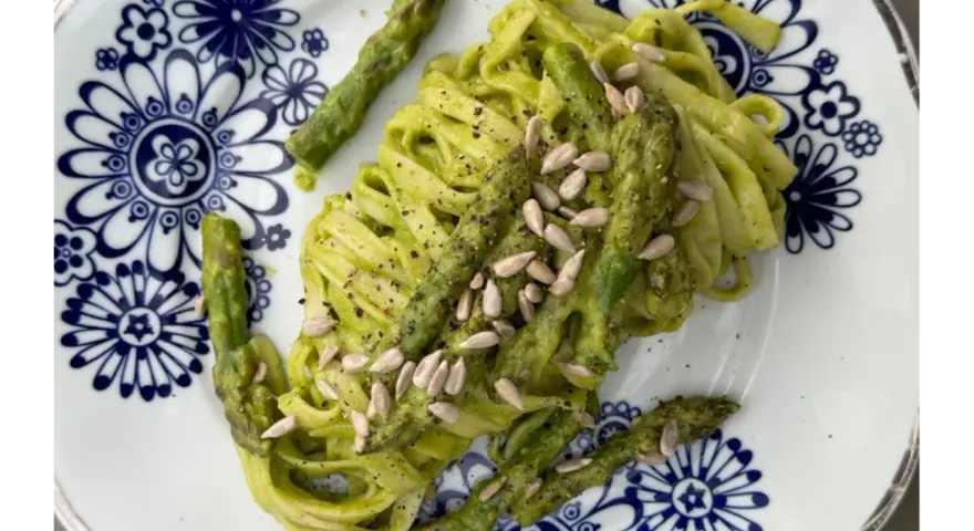 Makaron z zielonym pesto i szparagami, posypany pestkami słonecznika. Czy makaron jest zdrowy? Zależy od dodatków!