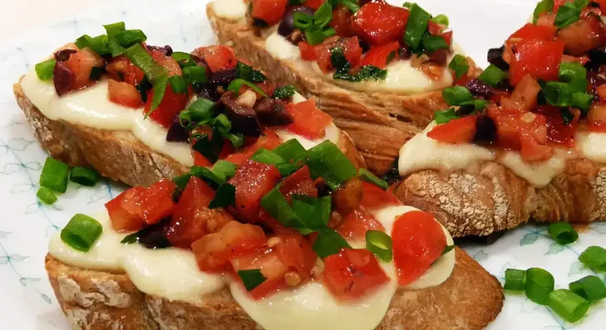 Bruschetta z pomidorami i mozzarellą: chrupiące pieczywo, roztopiony ser i świeże dodatki. Idealny przepis na szybką przekąskę.