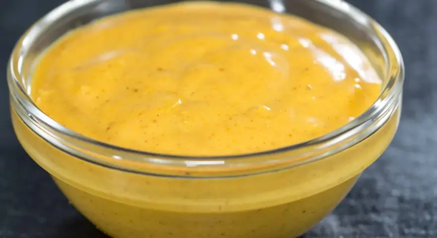 Gęsty, kremowy sos curry w szklanej miseczce, gotowy do podania z ulubionymi daniami.
