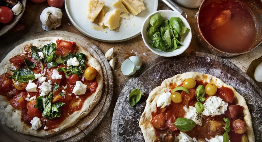 Dwie pizze margherita z pomidorami, mozzarellą i bazylią. Zastanawiasz się, ile kalorii ma pizza margherita?