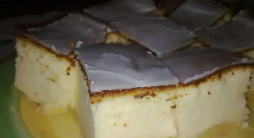 Pokrojony na kwadraty sernik tradycyjny z lukrem, idealny na prosty przepis.