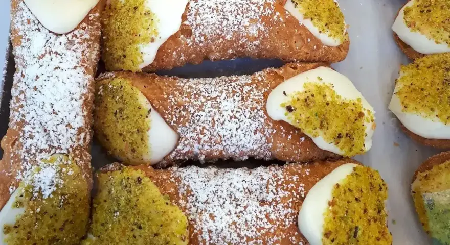 Chrupiące rurki wypełnione kremem i posypane pistacjami. Te pyszne **cannoli** wyglądają jak dzieła sztuki cukierniczej.