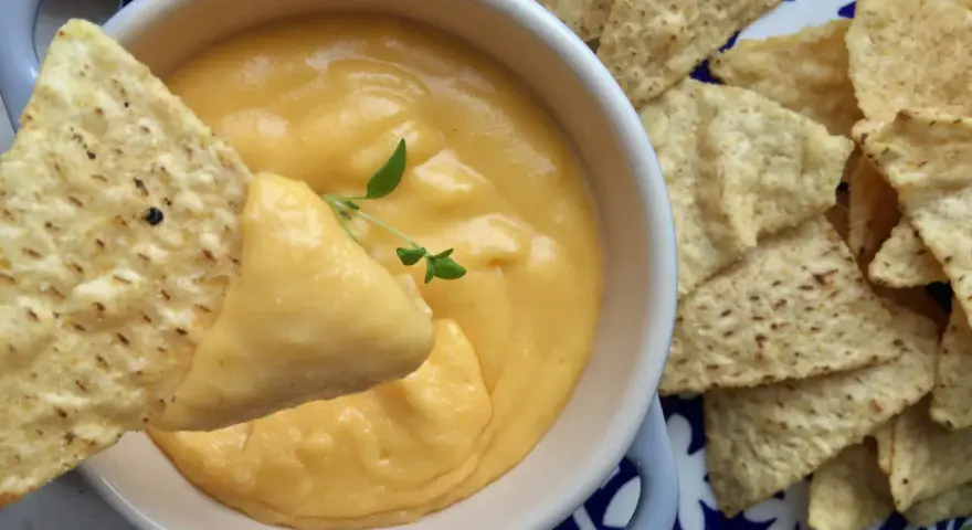 Chrupiące nachos zanurzane w kremowym sosie z serka topionego. Idealna przekąska na imprezę.
