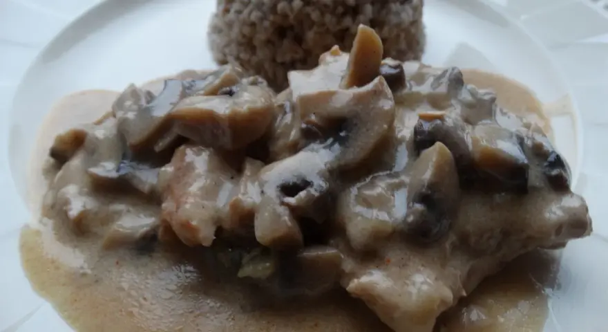 Pyszny schab duszony z pieczarkami w kremowym sosie, podany z kaszą gryczaną.