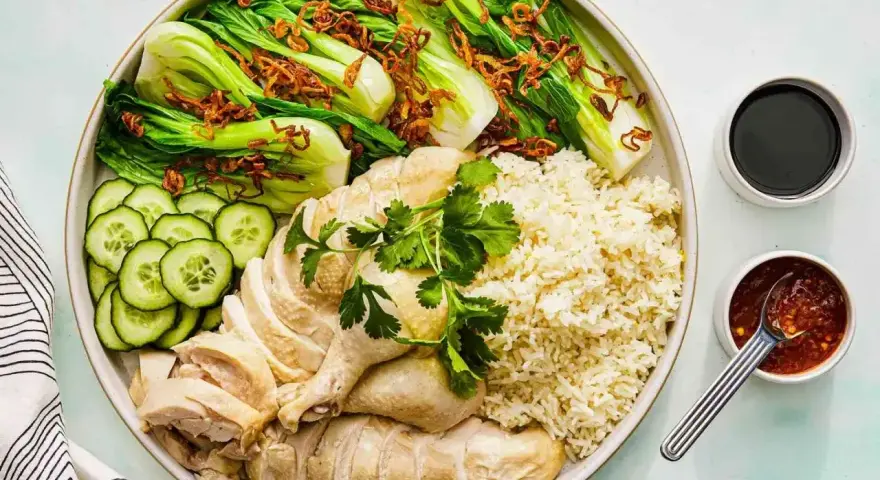 Pyszny kurczak hong kong z ryżem, pak choi, ogórkiem i sosami.